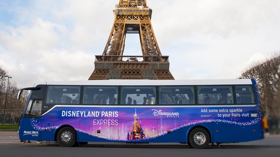 Hotel shuttle bus parked in front of the iconic Disney castle